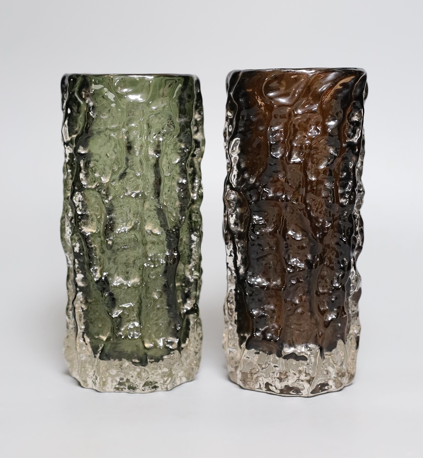 Two Whitefriars 'bark' cylinder vases, model 9689 designed by Geoffrey Baxter in 'sage' and 'cinnamon' glass, each 19cn high.